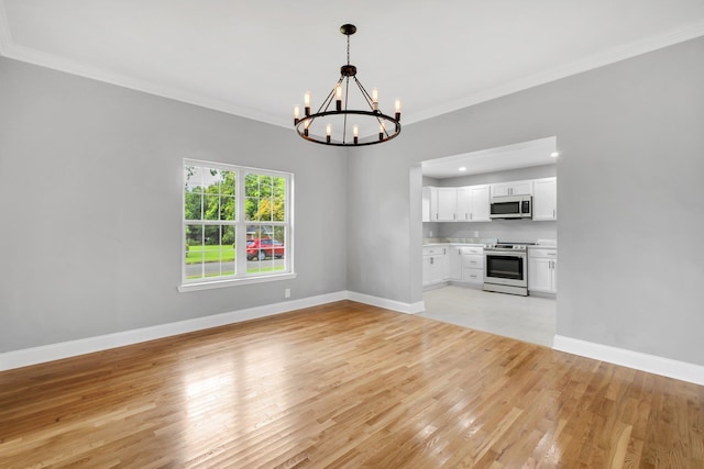 unfurnished living room featuring a notable chandelier, crown molding, and light hardwood / wood-style flooring