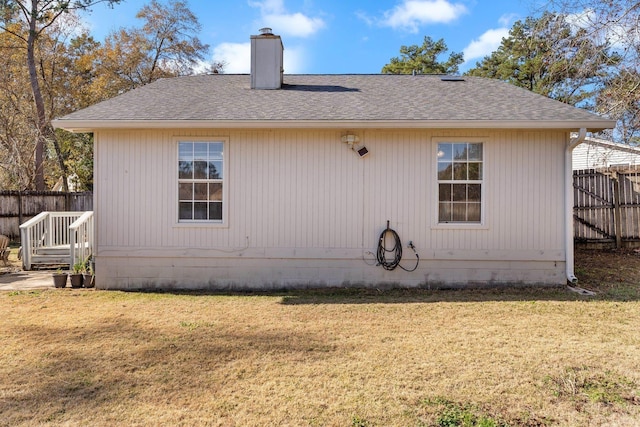 rear view of house featuring a lawn