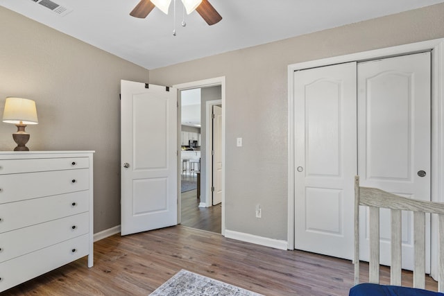 bedroom with ceiling fan, hardwood / wood-style floors, and a closet