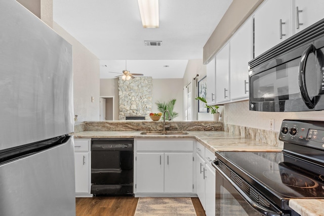 kitchen with sink, ceiling fan, white cabinetry, black appliances, and light wood-type flooring