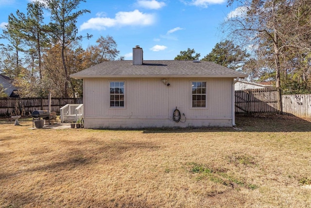 rear view of house featuring a lawn