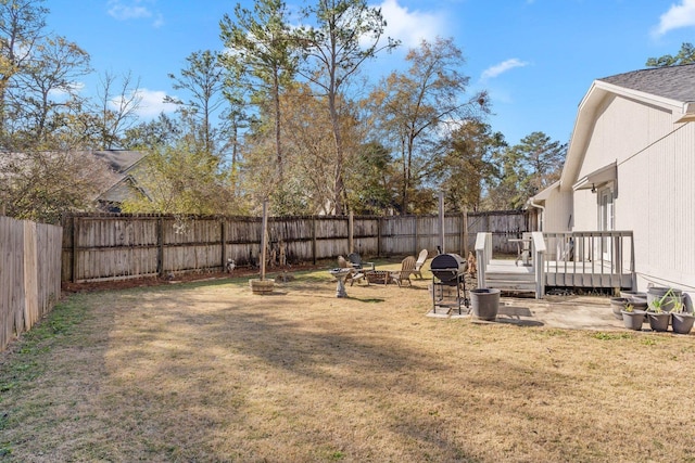 view of yard with a deck and a fire pit