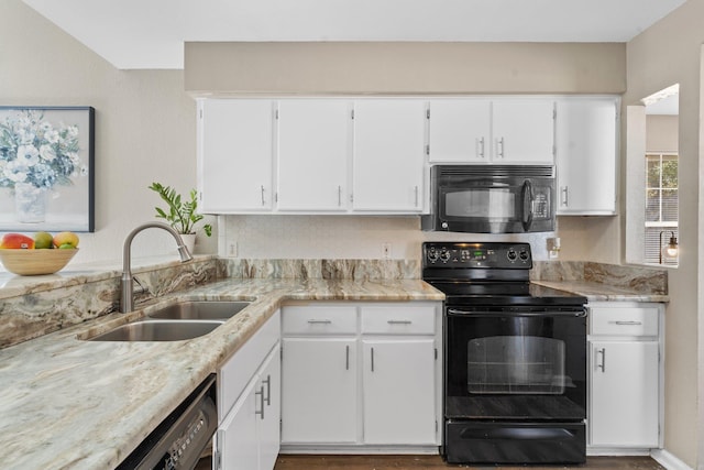 kitchen with white cabinetry, sink, light stone counters, and black appliances