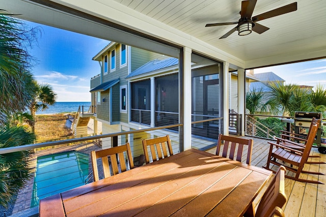 deck with grilling area, ceiling fan, and a water view