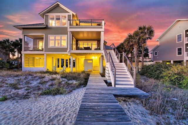 back house at dusk with a balcony