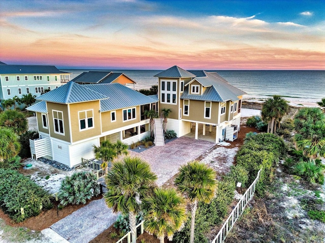 aerial view at dusk featuring a water view