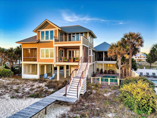 rear view of house featuring a balcony and a swimming pool