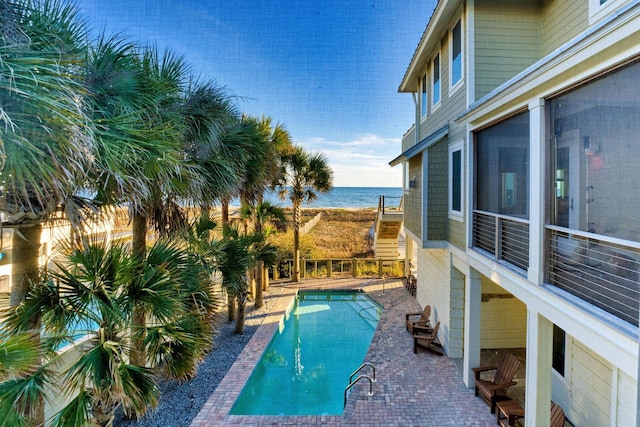 view of pool featuring a patio area and a water view