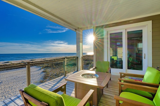 balcony featuring a view of the beach and a water view