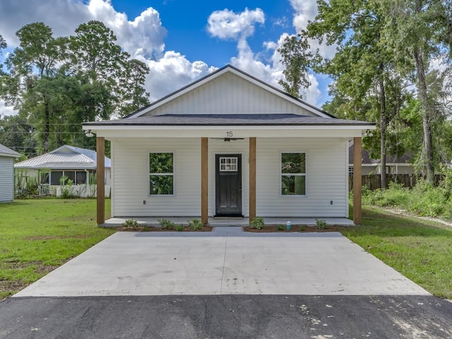 view of front of property featuring covered porch, board and batten siding, and a front yard