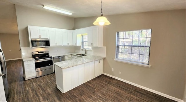2585 Panther Creek Rd, Tallahassee, FL 32308 - kitchen featuring stainless steel appliances, a peninsula, dark wood finished floors, white cabinetry, and lofted ceiling