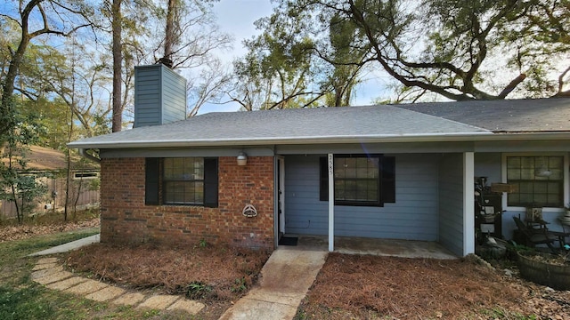 2585 Panther Creek Rd, Tallahassee, FL 32308 - view of front of house featuring a chimney, roof with shingles, and brick siding