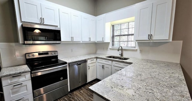 2585 Panther Creek Rd, Tallahassee, FL 32308 - kitchen with appliances with stainless steel finishes, dark wood-style floors, white cabinetry, and light stone counters