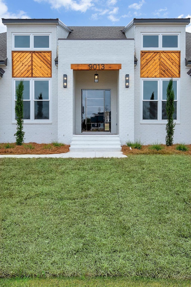 rear view of property with a lawn