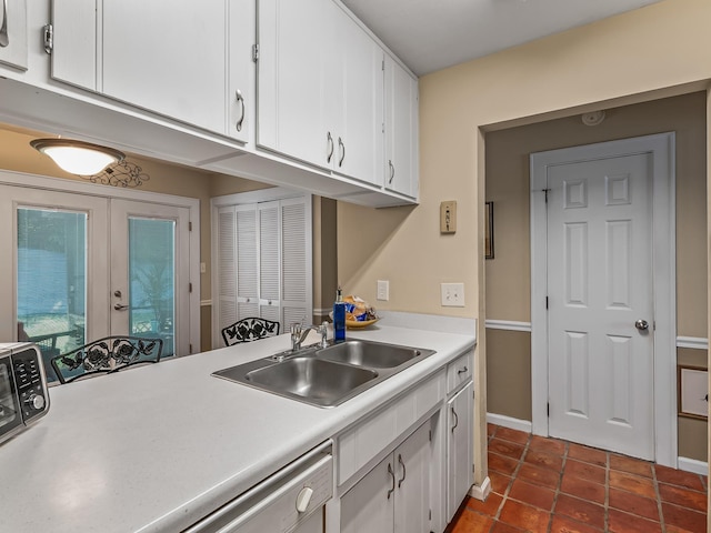 3104 Oak Hammock Ln Unit U, Tallahassee, FL 32301 - kitchen with french doors, light countertops, white cabinetry, dishwasher, and dark tile patterned floors