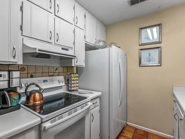 3104 Oak Hammock Ln Unit U, Tallahassee, FL 32301 - kitchen with white range with electric stovetop, under cabinet range hood, backsplash, light countertops, and white cabinetry