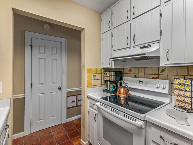 3104 Oak Hammock Ln Unit U, Tallahassee, FL 32301 - kitchen featuring white range with electric stovetop, under cabinet range hood, light countertops, white cabinets, and decorative backsplash
