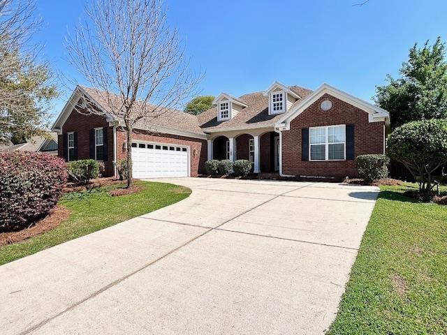2541 Lagrange Trl, Tallahassee, FL 32312 - view of front facade featuring brick siding, driveway, a garage, and a front yard