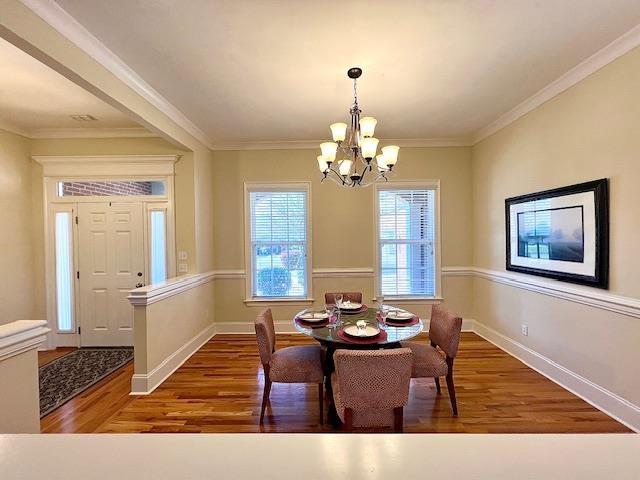 2541 Lagrange Trl, Tallahassee, FL 32312 - dining area with wood finished floors, a chandelier, baseboards, and ornamental molding