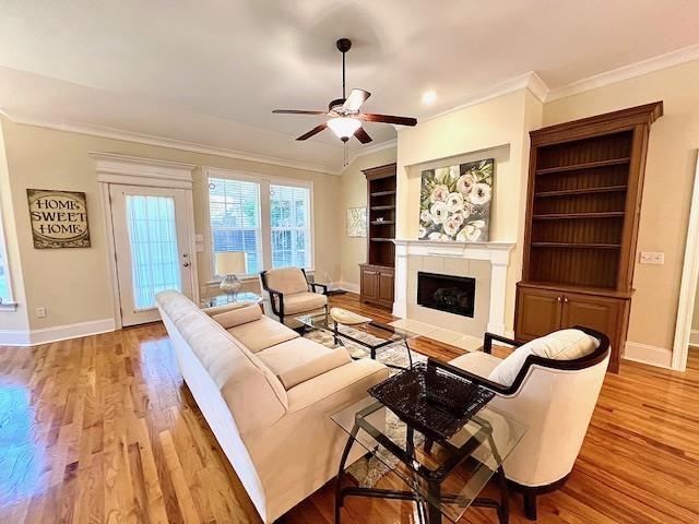 2541 Lagrange Trl, Tallahassee, FL 32312 - living room featuring crown molding, a ceiling fan, baseboards, wood finished floors, and a tiled fireplace