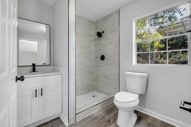 2314 Oxford Rd, Tallahassee, FL 32304 - full bath with toilet, wood finished floors, a tile shower, vanity, and baseboards