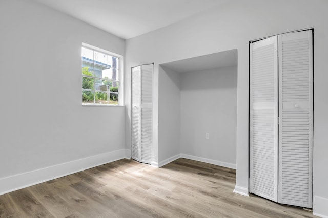 2314 Oxford Rd, Tallahassee, FL 32304 - unfurnished bedroom with two closets, light wood finished floors, and baseboards