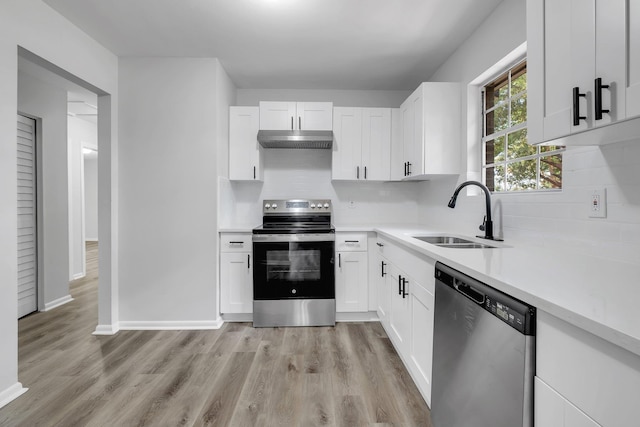 2314 Oxford Rd, Tallahassee, FL 32304 - kitchen with stainless steel appliances, a sink, under cabinet range hood, light countertops, and light wood finished floors
