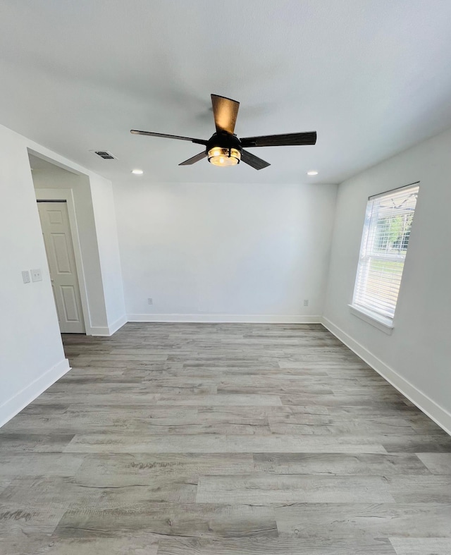 empty room with ceiling fan and light hardwood / wood-style floors