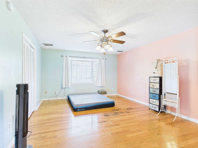 3696 Joel Aman Rd, Perry, FL 32347 - bedroom with light wood-style flooring, a textured ceiling, baseboards, and a ceiling fan