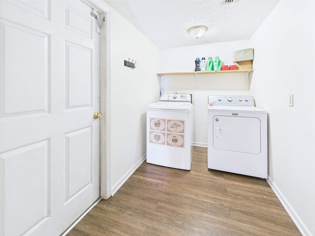 3696 Joel Aman Rd, Perry, FL 32347 - laundry room featuring washing machine and clothes dryer, wood finished floors, baseboards, and a textured ceiling