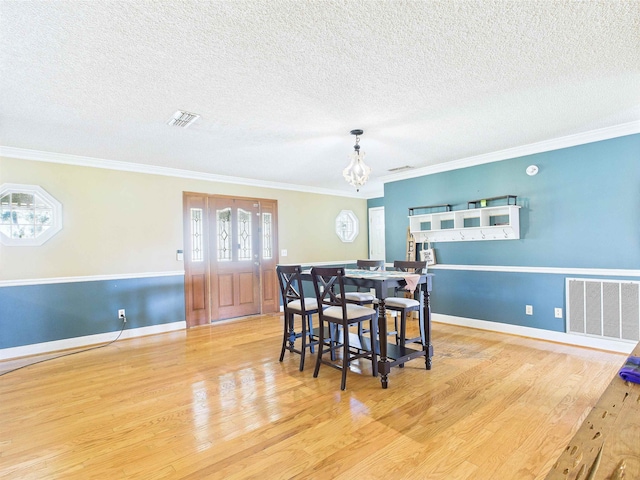 3696 Joel Aman Rd, Perry, FL 32347 - dining room with wood finished floors, ornamental molding, a textured ceiling, a chandelier, and baseboards