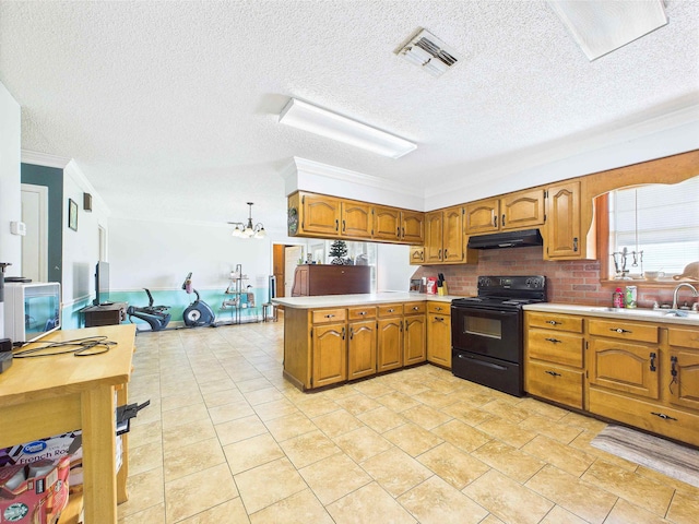 3696 Joel Aman Rd, Perry, FL 32347 - kitchen featuring electric range, under cabinet range hood, a peninsula, light countertops, and brown cabinetry