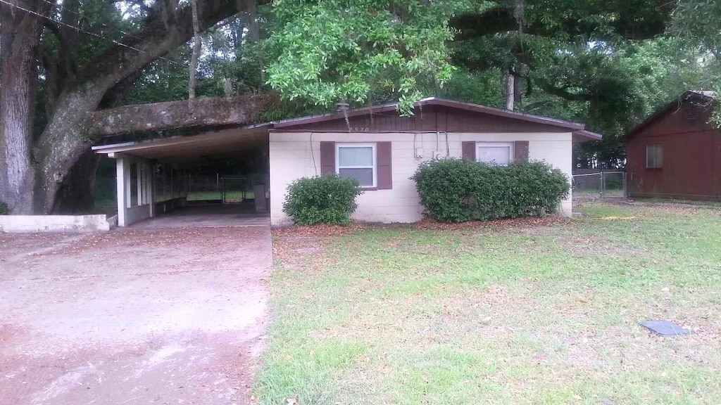 view of side of home with a lawn and a carport