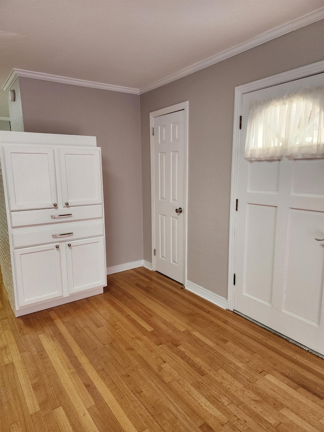 unfurnished bedroom featuring ornamental molding and light wood-type flooring