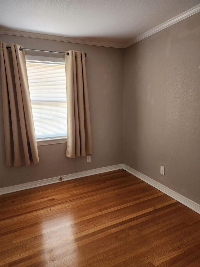 unfurnished room with hardwood / wood-style floors and ornamental molding