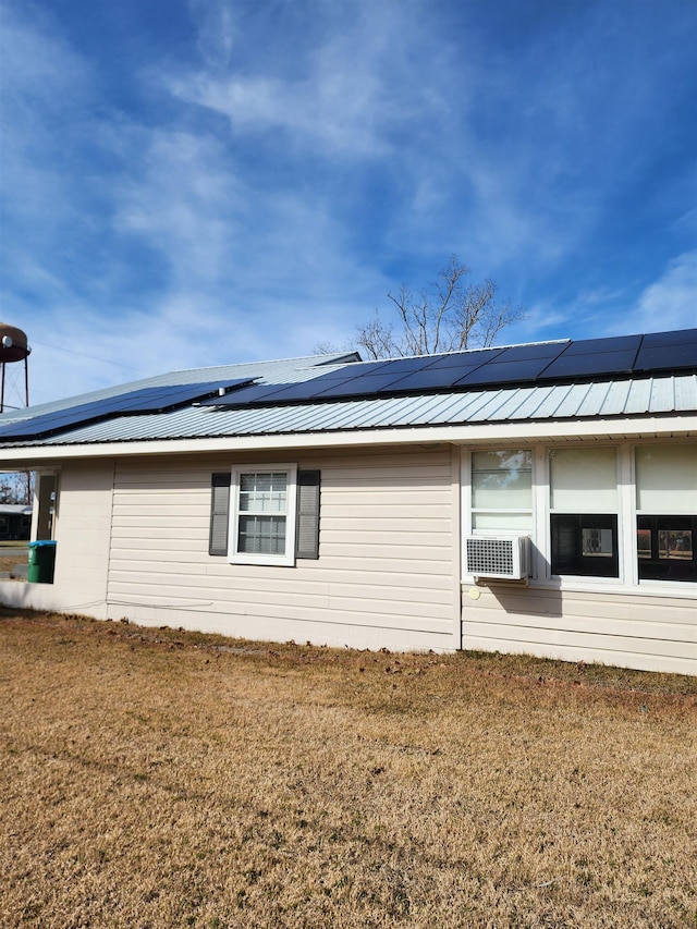 view of home's exterior with cooling unit, a lawn, and solar panels