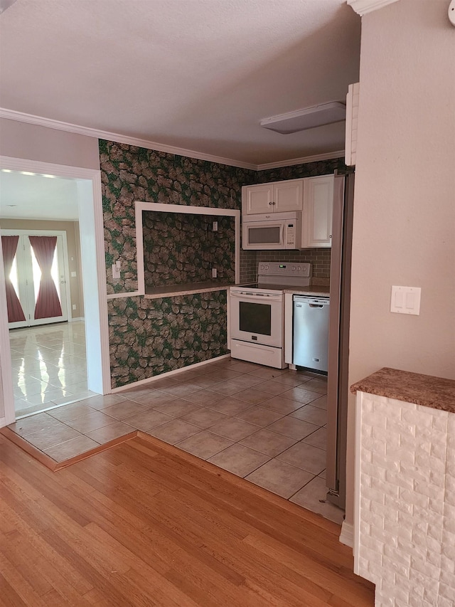 kitchen with white cabinetry, wood-type flooring, appliances with stainless steel finishes, and ornamental molding