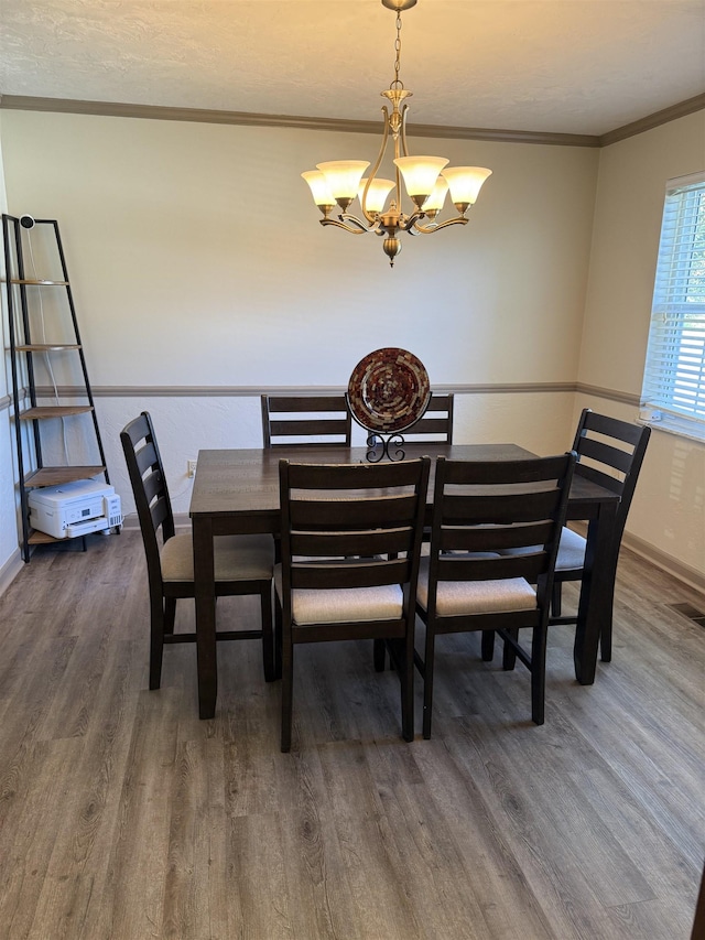 3726 Wicklow Cir, Tallahassee, FL 32309 - dining area with wood finished floors, a chandelier, and ornamental molding