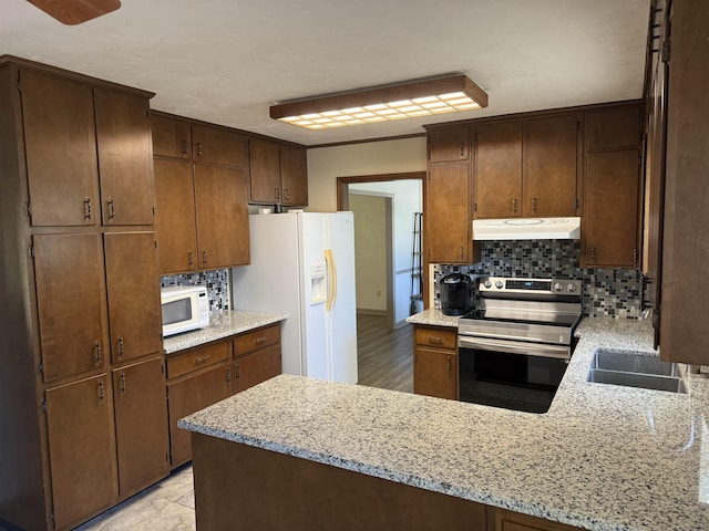 3726 Wicklow Cir, Tallahassee, FL 32309 - kitchen featuring white appliances, decorative backsplash, a peninsula, and under cabinet range hood