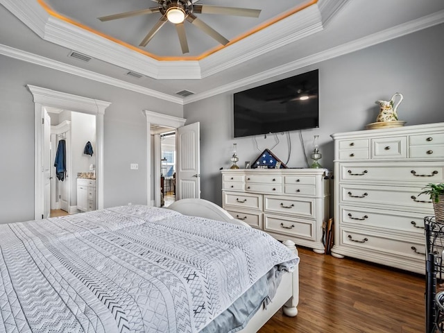 bedroom with a tray ceiling, ornamental molding, dark hardwood / wood-style floors, and ceiling fan