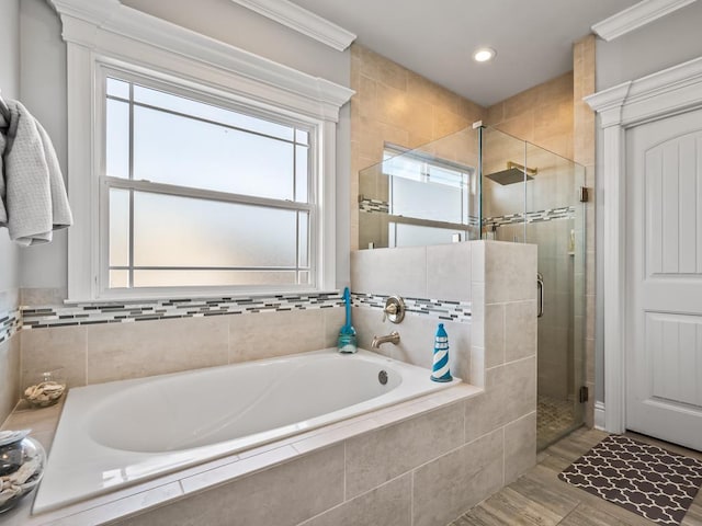 bathroom with crown molding and shower with separate bathtub