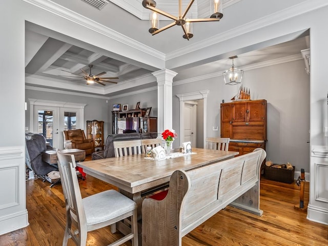 dining space featuring coffered ceiling, ornamental molding, and light hardwood / wood-style floors