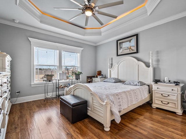 bedroom featuring ornamental molding, dark hardwood / wood-style floors, ceiling fan, and a tray ceiling