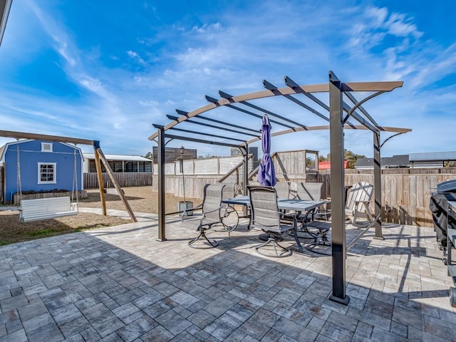 view of patio / terrace with a storage unit and a pergola