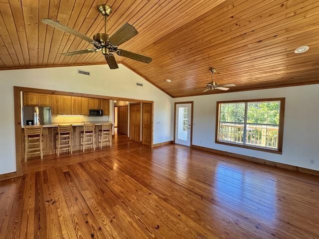 unfurnished living room featuring high vaulted ceiling, dark hardwood / wood-style floors, ceiling fan, and wood ceiling