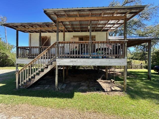 rear view of property featuring a yard and a wooden deck