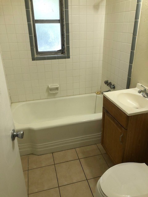 bathroom featuring shower / bathtub combination, vanity, tile patterned flooring, and toilet