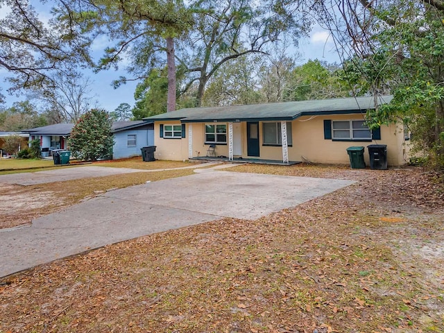 ranch-style home featuring covered porch and driveway