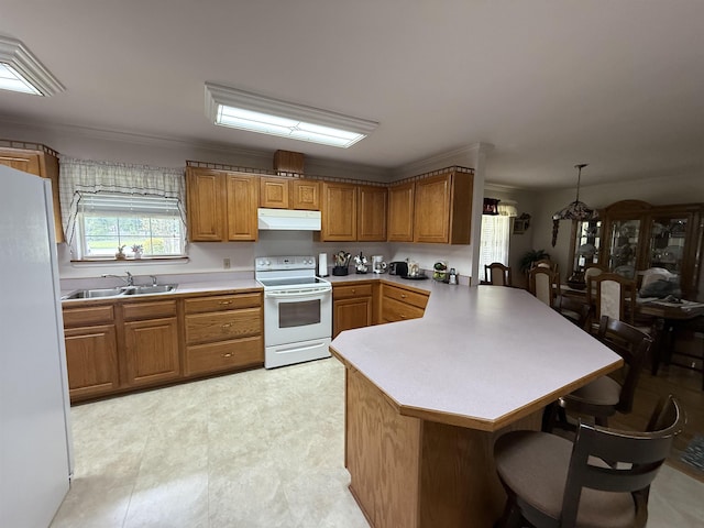 601 Judson Dr, Perry, FL 32348 - kitchen with white appliances, under cabinet range hood, a peninsula, a kitchen bar, and brown cabinetry
