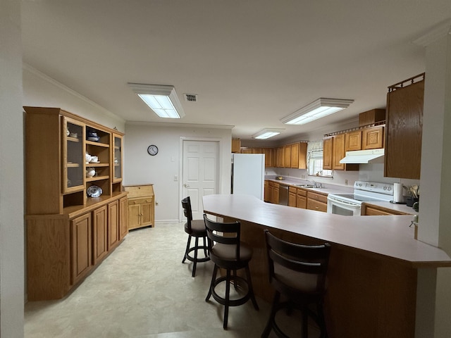 601 Judson Dr, Perry, FL 32348 - kitchen with white appliances, under cabinet range hood, a peninsula, light flooring, and crown molding